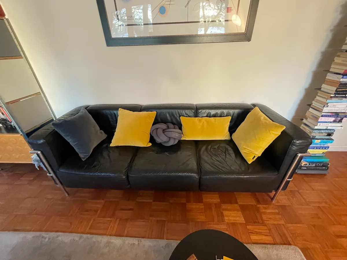 Black leather sofa after severe cat scratch damage repair — panel replacement by Leather & Vinyl Care NYC