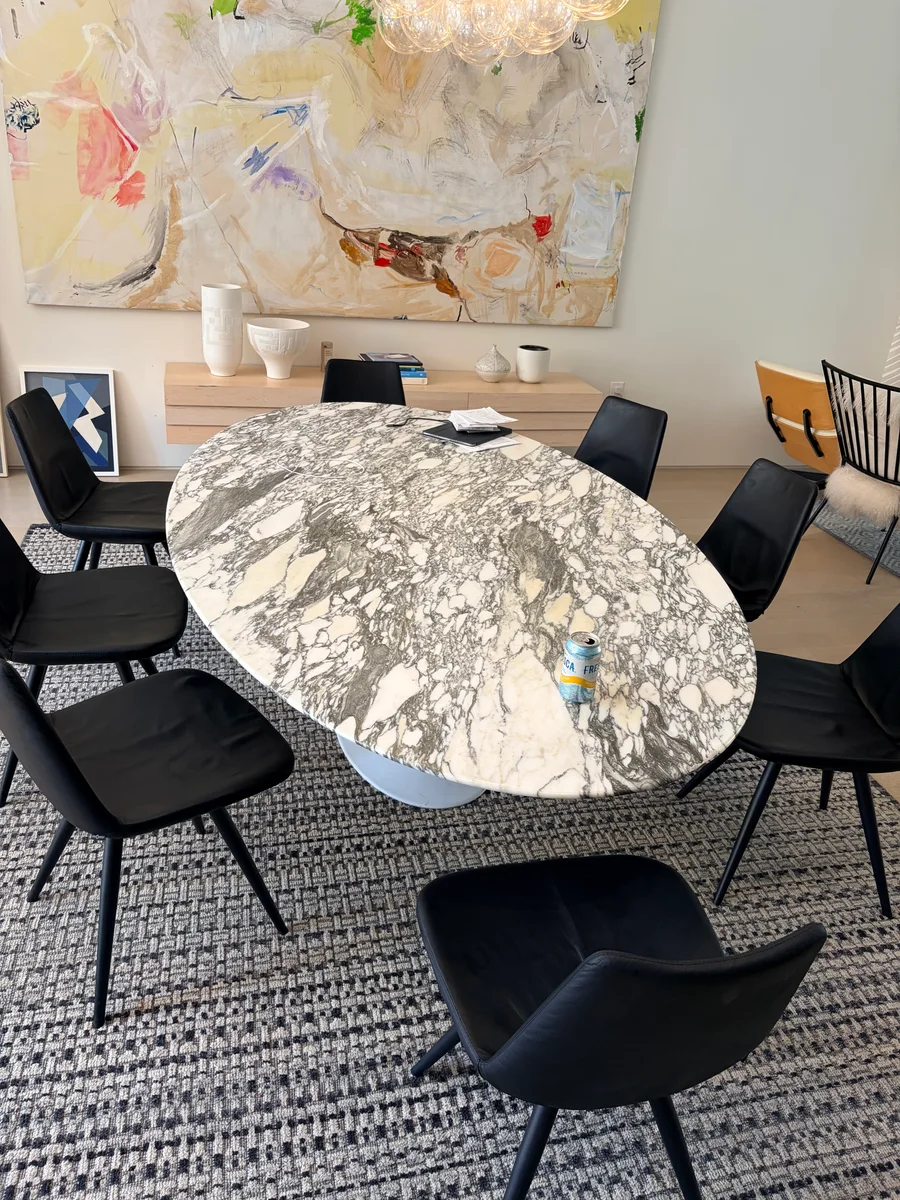 Eight restored black leather chairs arranged around a dining table in Clinton Hill, Brooklyn