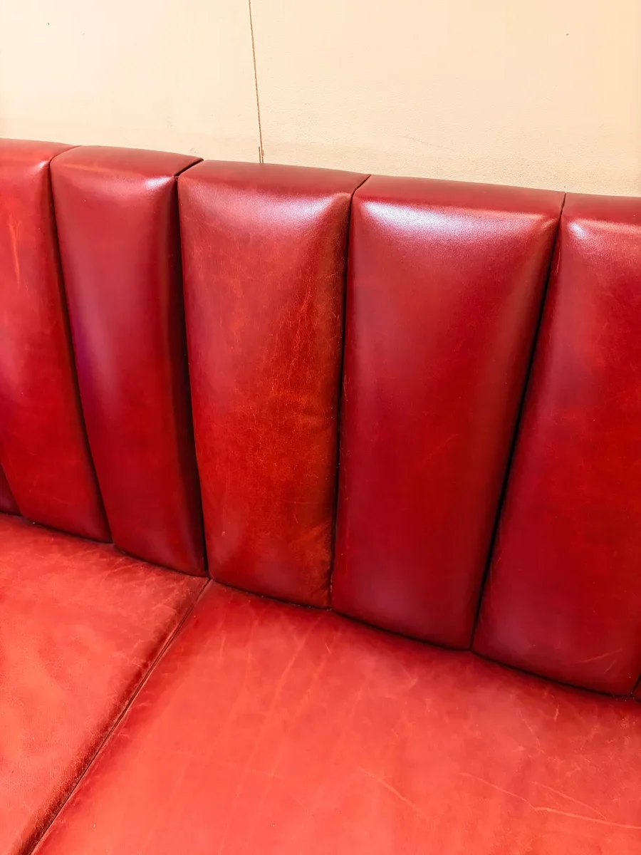 Restaurant leather banquette in Midtown Manhattan after commercial booth repair — deep burgundy leather, repaired corners rebuilt